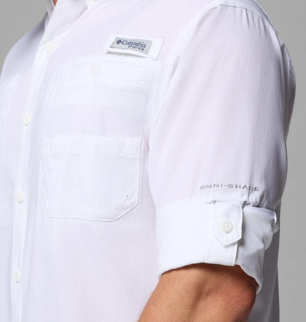 אדם לובש חולצת קולומביה IL Tamiami II L/S לבנה, ששרווליה מגולגלים חלקית. הלוגואים הנראים לעין כוללים את הכיתוב "columbiaIL" על התווית בחזה ואת הכיתוב "OMNI-SHADE" על השרוול.