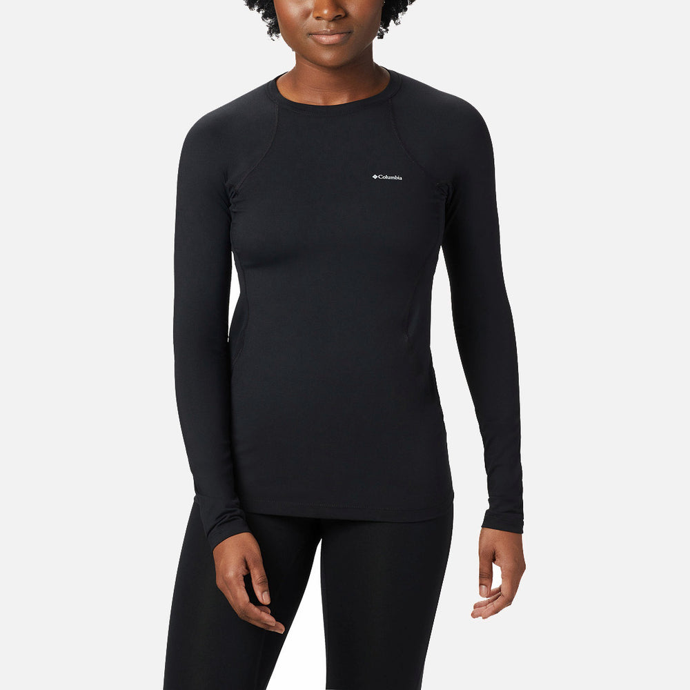 אדם לבוש בחולצת קולומביה IL Midweight Stretch ארוכת שרוולים בצבע שחור, המותאמת לגופו, ובמכנסיים שחורים, עומד עם הפנים קדימה על רקע לבן חלק.