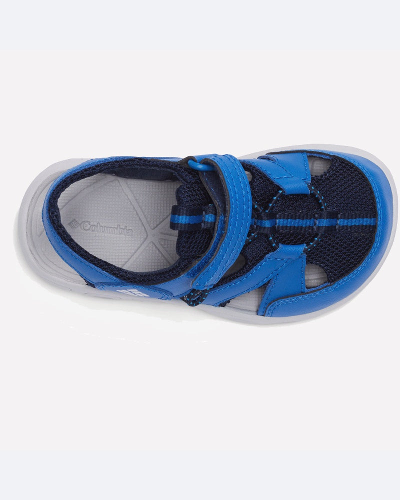 מבט מלמעלה על סנדל פתוח מקדימה מדגם "Techsun Wave" של ColumbiaIL לילדים, בצבעים כחול ושחור, עם סוליה אפורה ורצועת ולקרו. המבנה המשלב רשת וחומר סינתטי מעניק אוורור, מה שהופך אותו לאידיאלי כנעלי קיץ לילדים או כסנדלי מים.