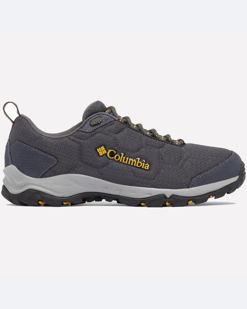 נעלי טיולים מדגם Firecamp Remesh של ColumbiaIL בצבע אפור, עם נגיעות של שחור וצהוב, לוגו צהוב בצד, סוליה מגומי מחוספסת ושרוכים אפורים, מוצגות בצילום צדדי על רקע בהיר אחיד.