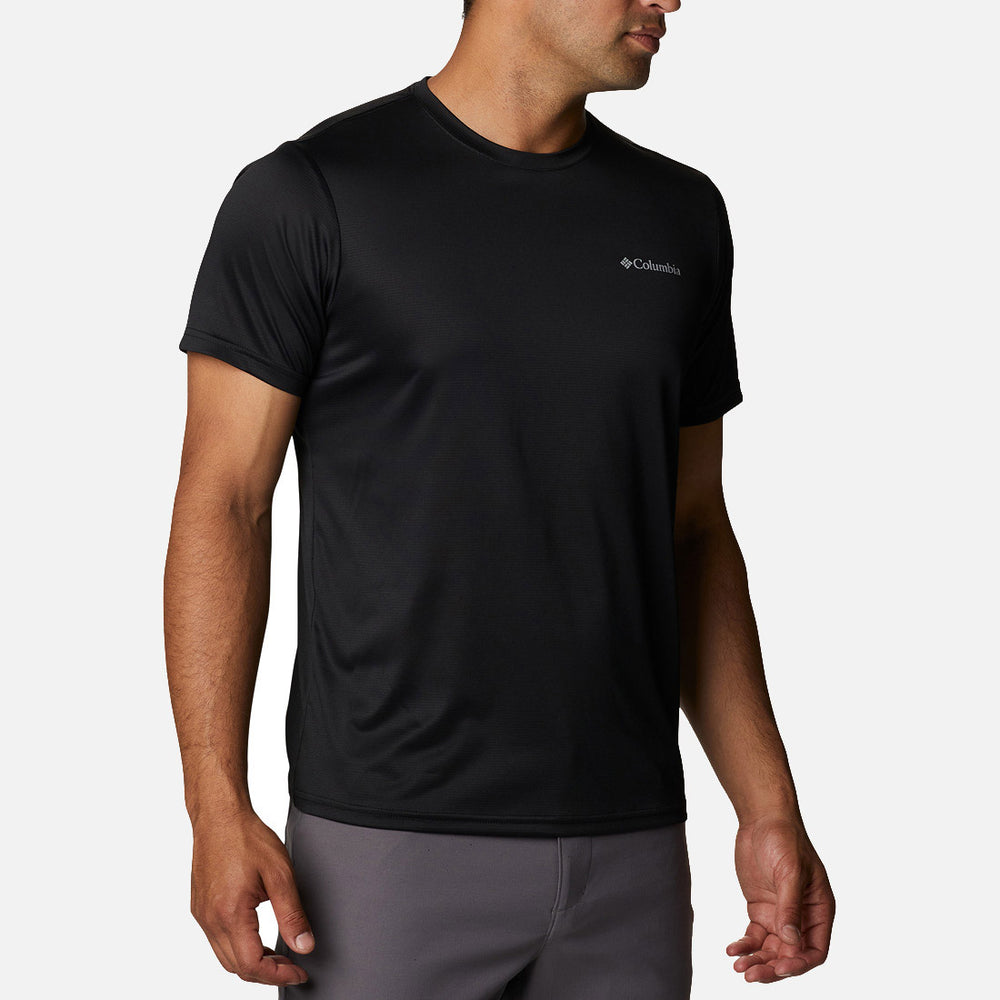 A man wearing a Columbia Hike Crew Black t-shirt and gray pants stands against a plain white background.