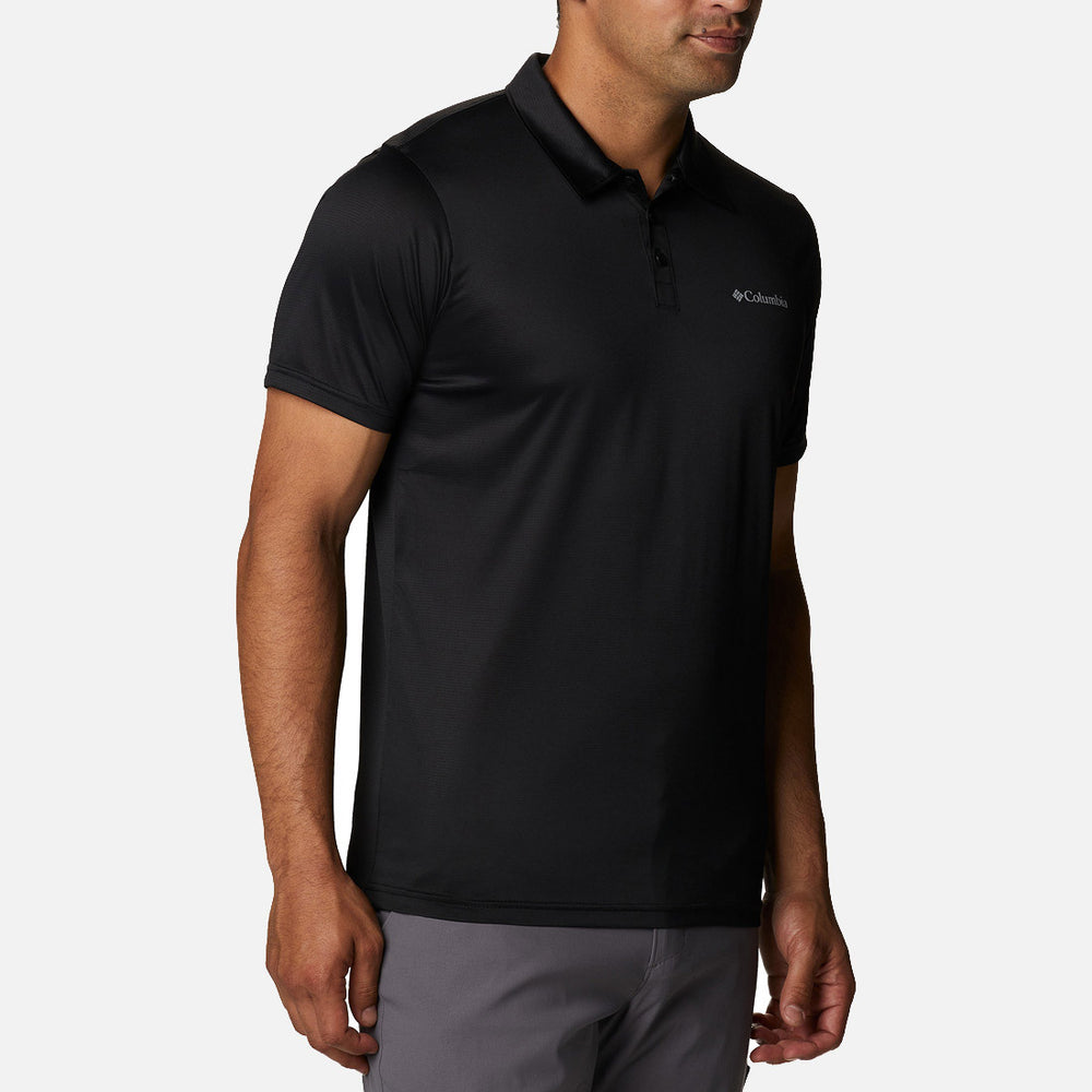 גבר לבוש בחולצת "Columbia Hike Polo Black" מבית columbiaIL — חולצת פולו עם צווארון ושרוולים קצרים, בעלת שלושה כפתורים — עומד על רקע לבן אחיד.