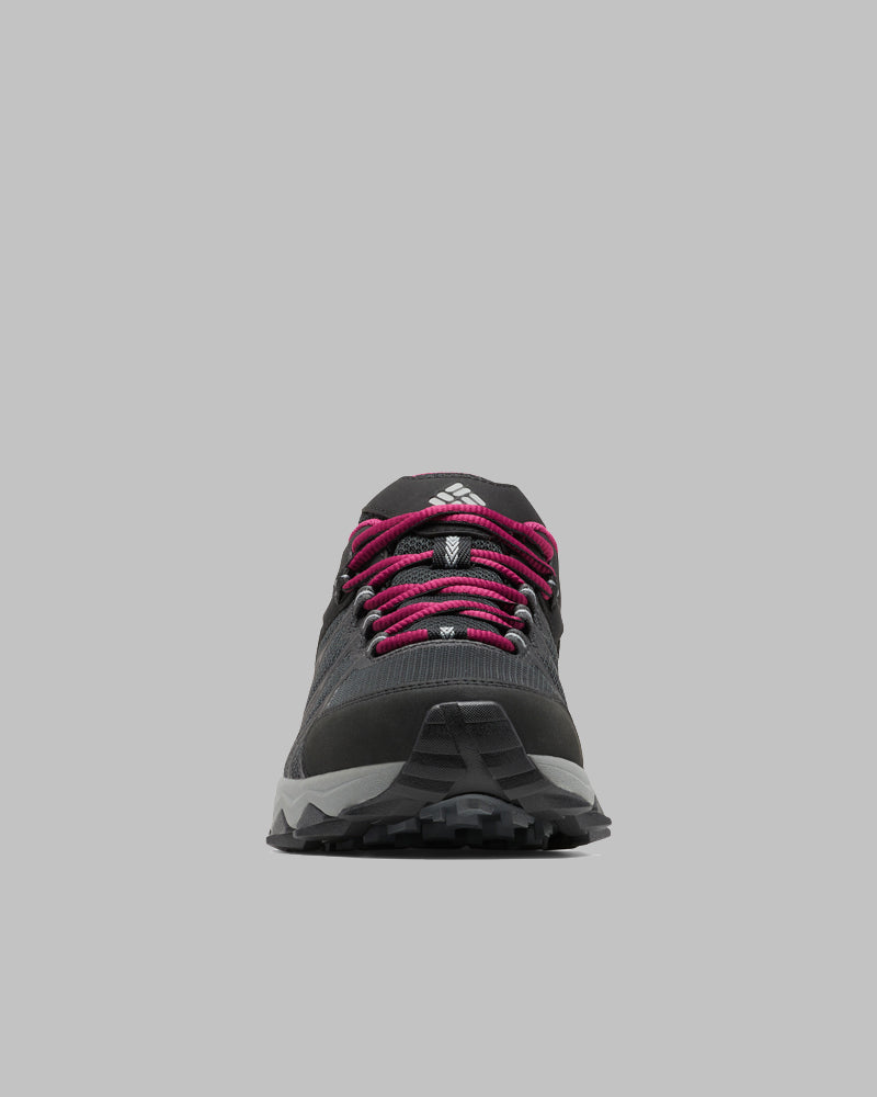 מבט מלפנים על נעל טיולים לנשים מדגם Columbia IL Peakfreak II Outdry W בצבע שחור, עם שרוכים בצבע מג'נטה, סוליה אפורה ולוגו לבן על הלשון, המוצגת על רקע אפור אחיד.