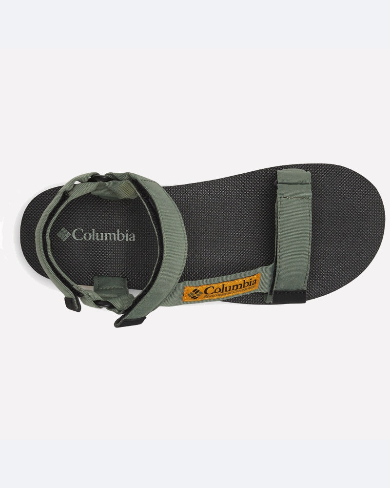 מבט מלמעלה על סנדלי ה-Breaksider של ColumbiaIL, עם סוליה שחורה, רצועות מתכווננות בצבע ירוק זית ותווית לוגו צהובה של ColumbiaIL בקשת כף הרגל.