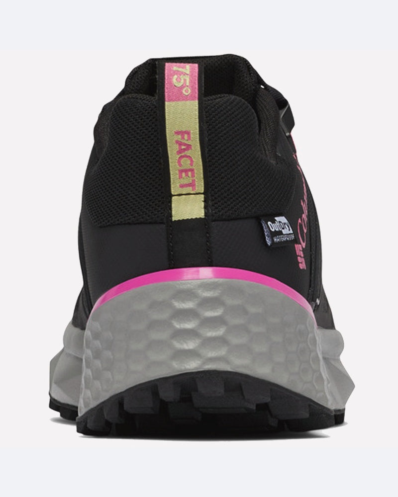 מבט מאחור על דגם columbiaIL Facet 75 Outdry W מגלה נעל ספורט שחורה עם סוליה אפורת ומרקמת, פס ורוד בעקב, לוגו בצבעים צהוב וורוד, ותווית אטימות למים OD WS OutDry להגנה נוספת.