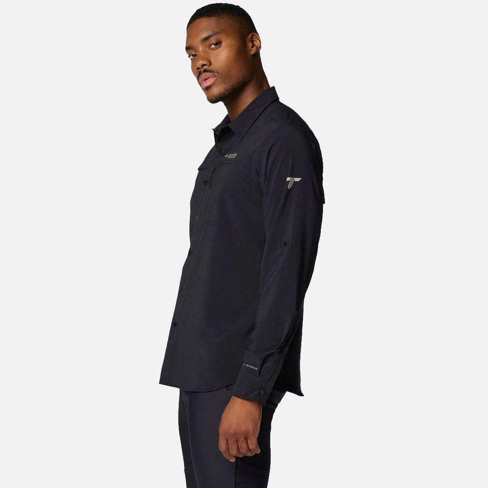 גבר המוצג בפרופיל לובש את חולצת ה-Summit Valley Woven L/S של ColumbiaIL ומכנסיים שחורים על רקע לבן. החולצה הקז'ואלית לגברים כוללת כפתורים ולוגואים קטנים על החזה והשרוול.
