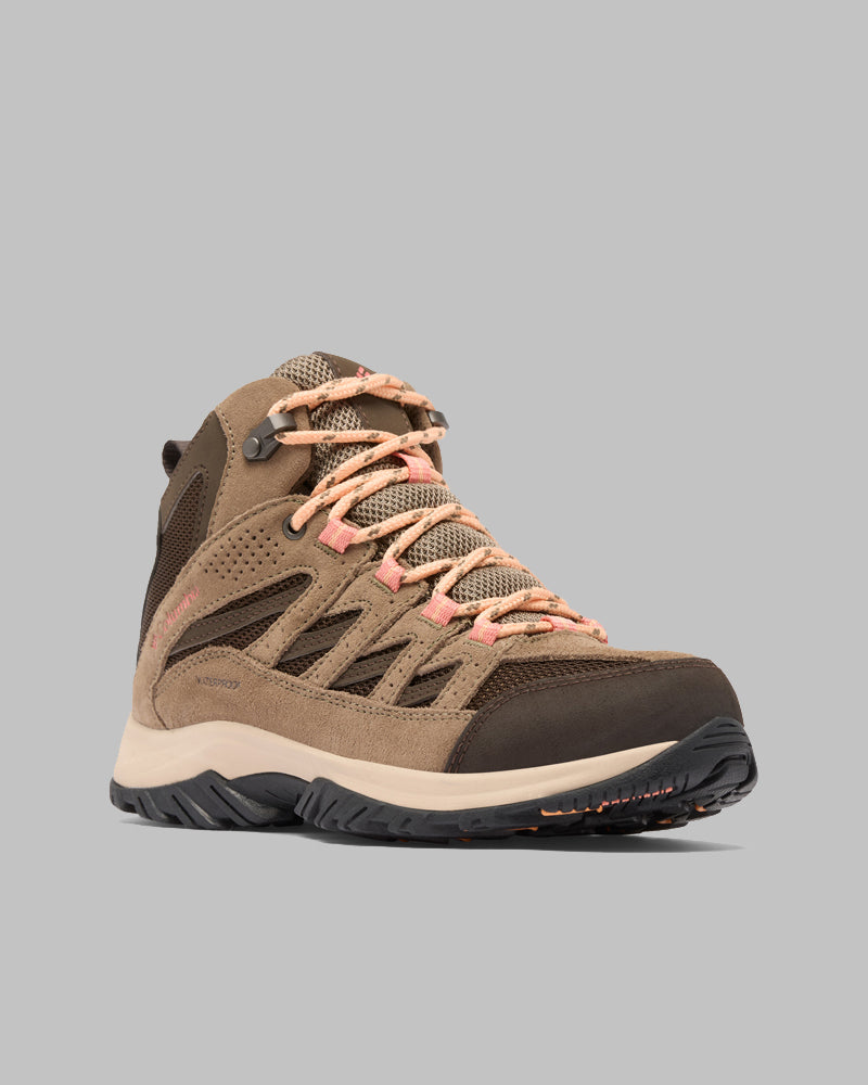 מגפי הטיולים לנשים "Crestwood Mid Waterproof W" של קולומביה ישראל, בצבעי חום ובז', כוללים שרוכים בצבע אפרסק, לוחות רשת נושמים וסוליה עמידה בצבעי שחור ובז', כפי שמוצג בתמונה על רקע אפור אחיד.