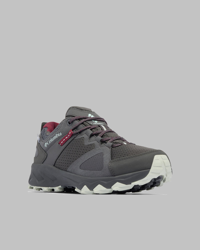 נעל הטיולים Peakfreak Hera Outdry של קולומביה ישראל, בצבע אפור עם נגיעות בורדו, לוחות רשת וסוליה לבנה ועמידה, מוצגת על רקע אפור בהיר — אידיאלית להרפתקה הבאה שלכם בטבע.