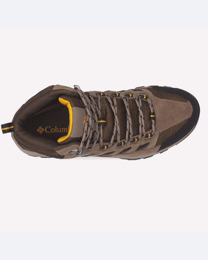 מבט מלמעלה על נעל טיולים חומה ושחורה מדגם ColumbiaIL Crestwood Mid Waterproof, עם שרוכים אפורים, נגיעות צהובות ועיצוב מחוספס, המוצגת על רקע לבן.