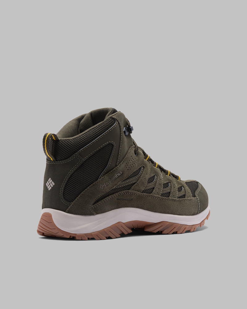 מגף Crestwood Mid Waterproof מבית קולומביה ישראל בצבע ירוק זית ושחור, עם סוליה אמצעית לבנה, סוליה חיצונית חומה ואלמנטים צהובים, מוצג בזווית המאפשרת לראות את הצד החיצוני ואת החלק האחורי על רקע אפור אחיד.