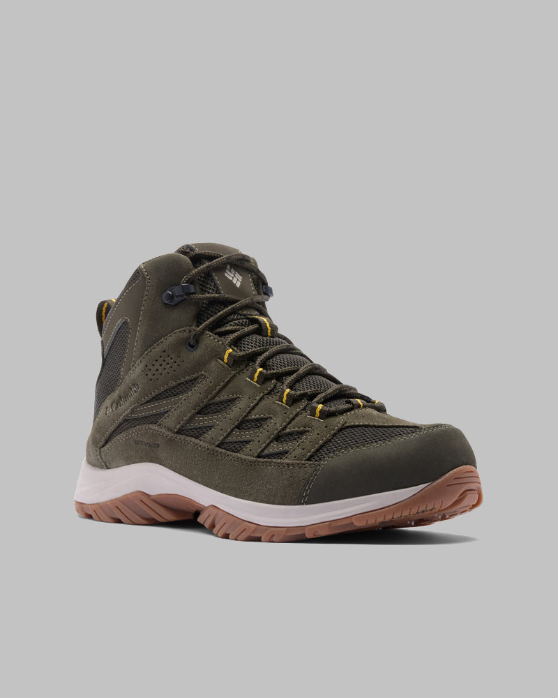 מגף טיולים בודד מדגם "קולומביה ישראל Crestwood Mid Waterproof" בצבע ירוק זית עם נגיעות צהובות, לוחות רשת שחורים וסוליה חומה מגומי מוצג בזווית קלה על רקע אפור בהיר.