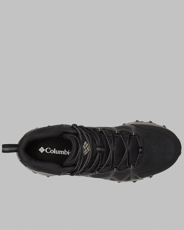 מבט מלמעלה על נעל Columbia IL Peakfreak II Mid Outdry M בצבע שחור, עם פרטי רשת, שרוכים שחורים ולולאה בעקב על רקע אפור. לוגו קולומביה מופיע על רפידת הנעל, מה שמדגיש את הסגנון של מגפי הטיולים לגברים.