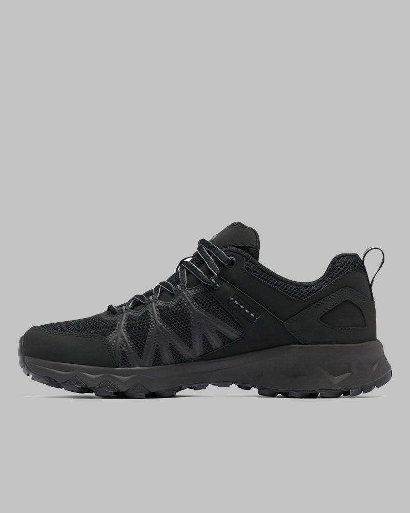 דגם Peakfreak II Outdry של ColumbiaIL, המוצג בפרופיל צדדי על רקע אפור, הוא נעל ספורט שחורה עם סוליה מחוספסת, לוחות רשת וחיפויים תומכים — הנעל המושלמת לפעילויות בחוץ, המשלבת סגנון ופרקטיות.