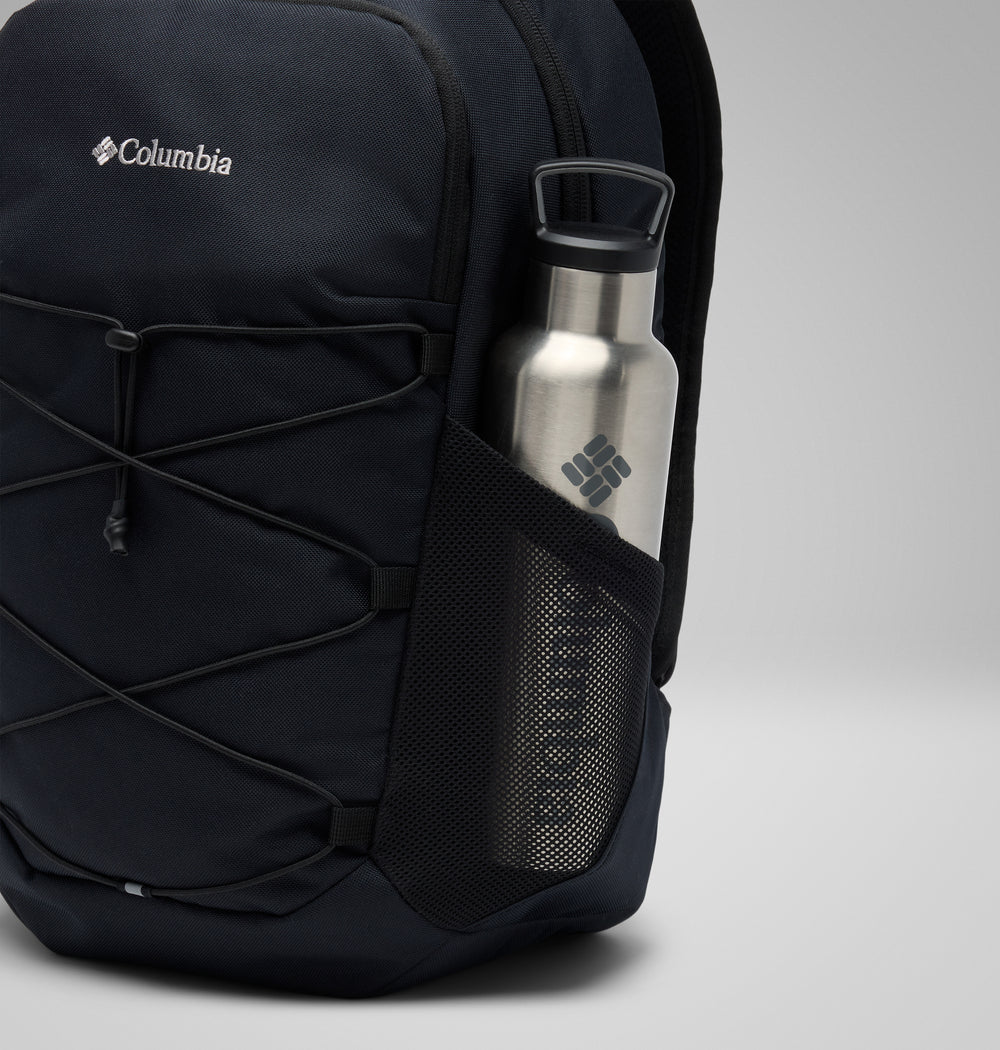 תיק גב שחור מדגם "Atlas Explorer 20L" של קולומביה ישראל, עם חוט אלסטי בחזית וכיס צדדי מרשת המכיל בקבוק מים מפלדת אל-חלד, שניהם נושאים את הלוגו של קולומביה ישראל, על רקע אפור בהיר אחיד.