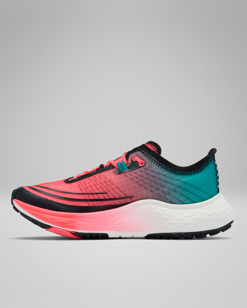 נעל הריצה לשטח לנשים "קולומביה ישראל Konos Speed Trail Atr W" מתאפיינת בגרדיאנט צבעים מוורוד אלמוג ועד טורקיז, עם נגיעות שחורות וסוליה לבנה עבה ומרקמת, המוצגת על רקע אפור אחיד — אידיאלית לריצות מהירות בשטח.