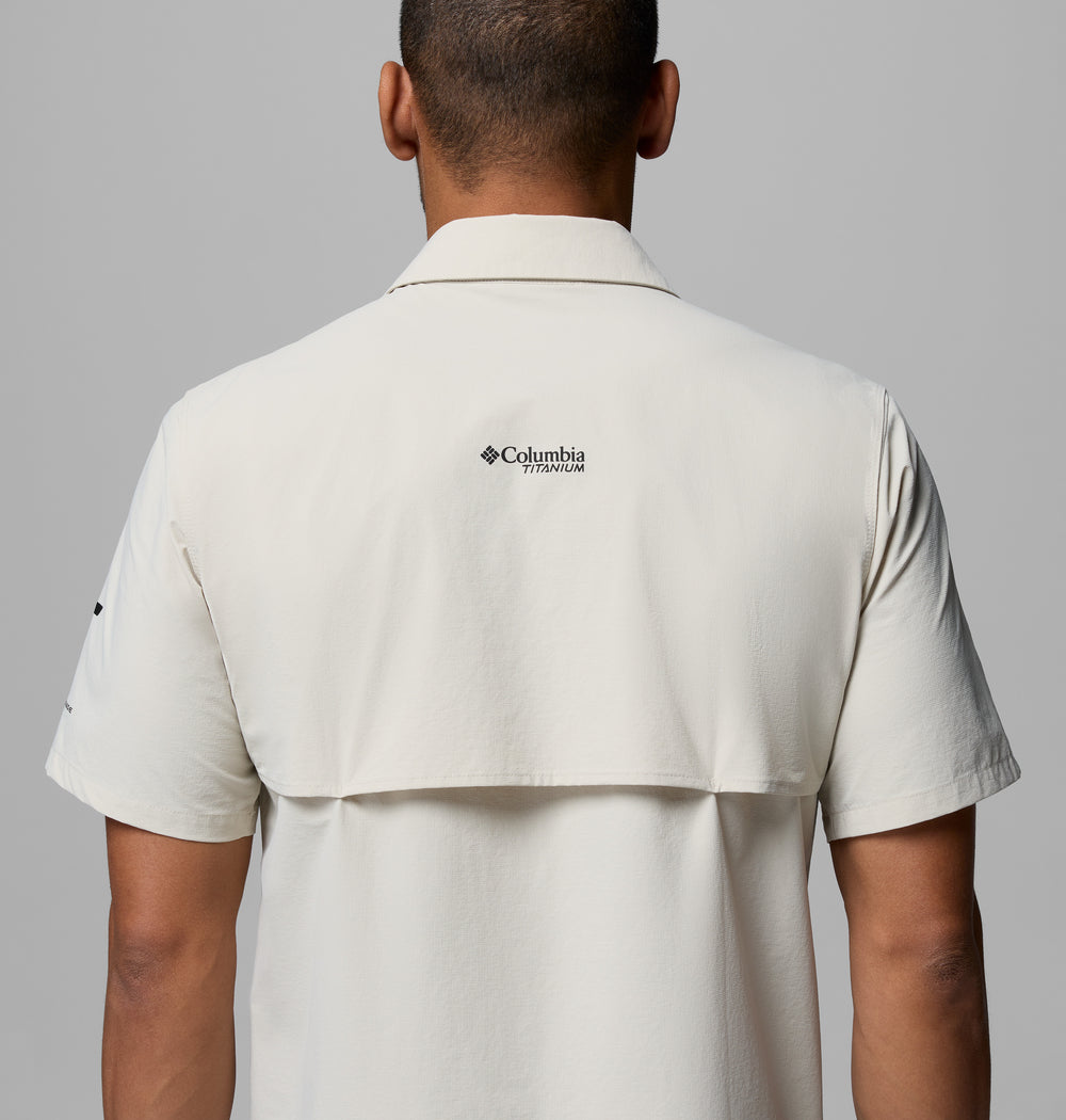 אדם נראה מאחור לבוש בחולצת "Silver Ridge Elite S/S Woven" בהירה מבית קולומביה ישראל, עם לוגו המותג בחלק העליון של הגב, על רקע אפור אחיד.