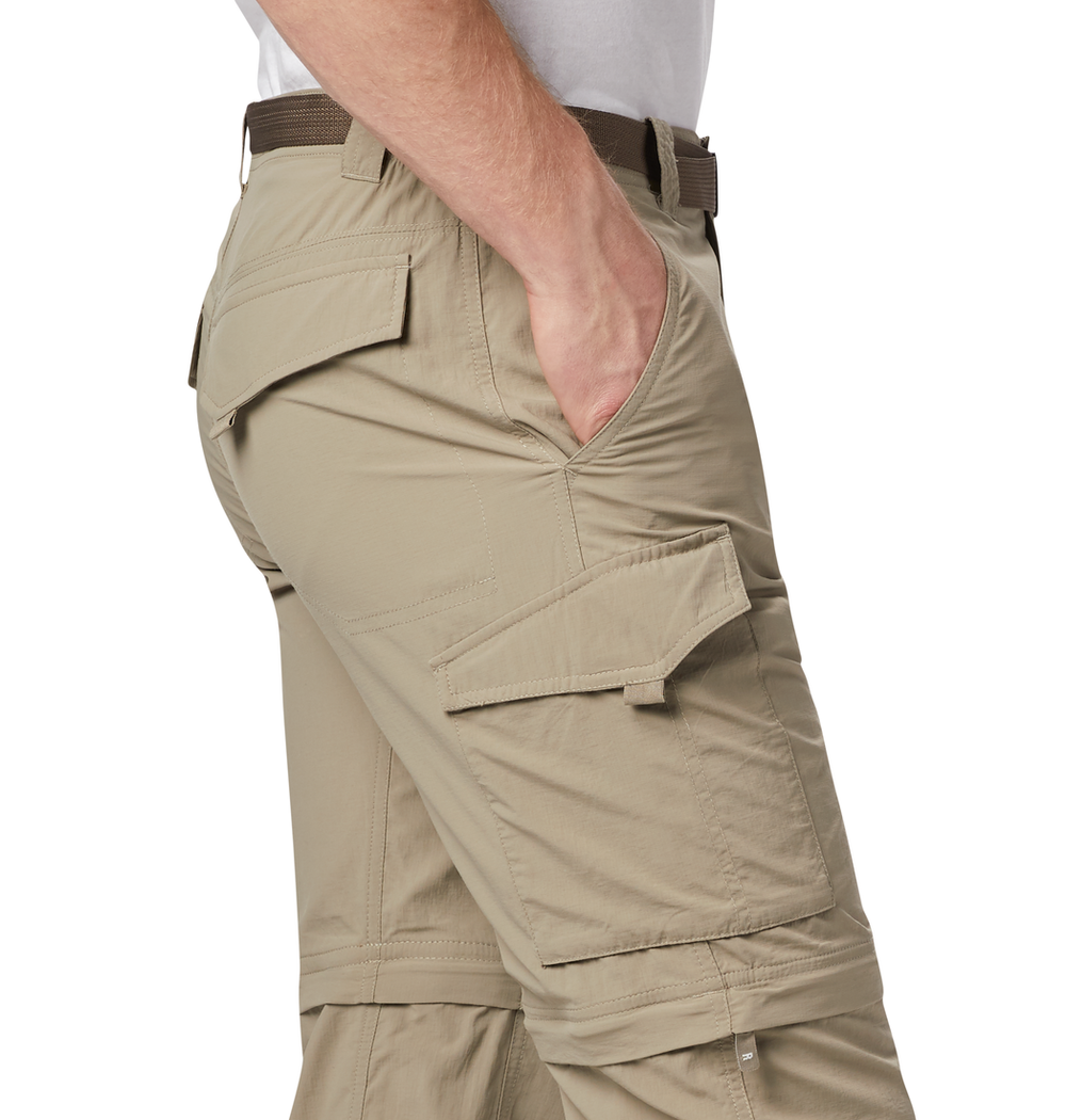 אדם לובש מכנסיים קלים בצבע חאקי מדגם ColumbiaIL Silver Ridge II Convertible, הכוללים כיסים רבים, בהם כיס עם דש בירך, עם חגורה כהה. יד אחת מונחת בכיס הקדמי; נראים רק האזור שבין המותניים לברכיים.