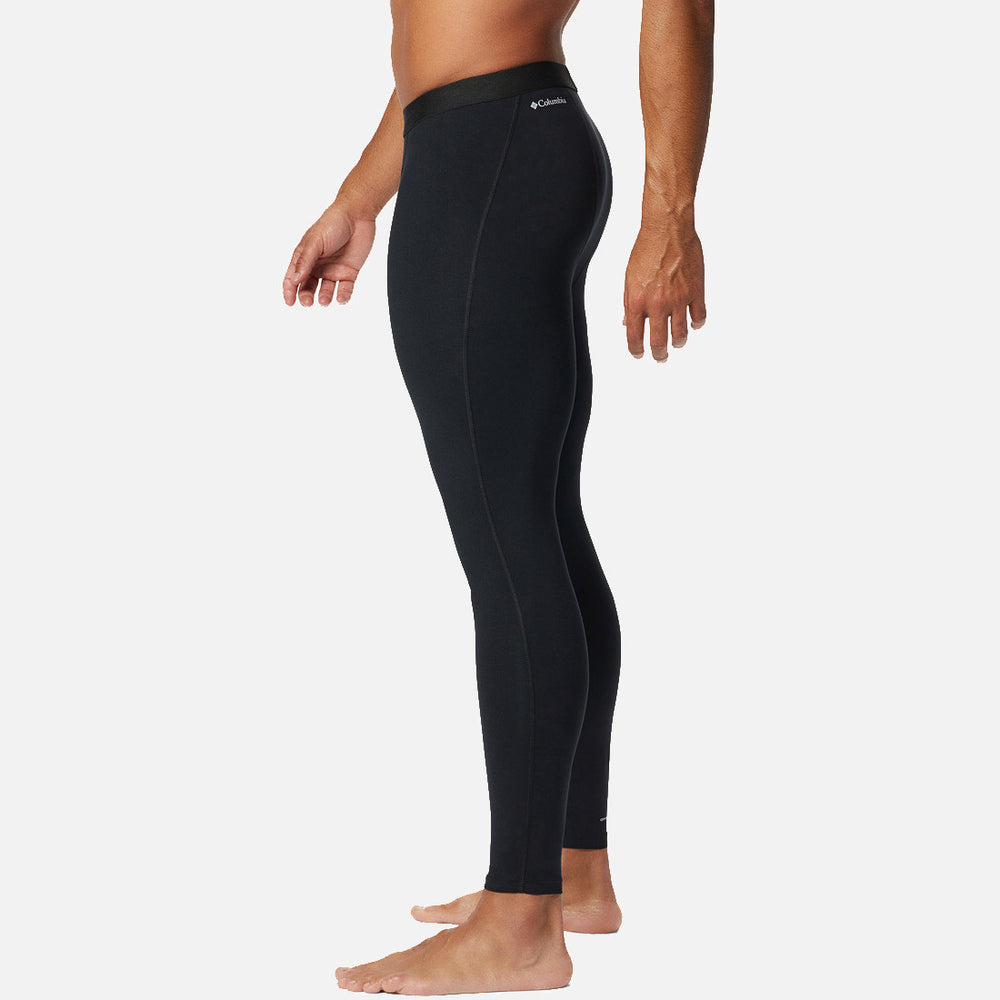 גבר עומד בפרופיל, יחף, לבוש במכנסי טייץ "ColumbiaIL Midweight Stretch Baselayer", על רקע לבן חלק.