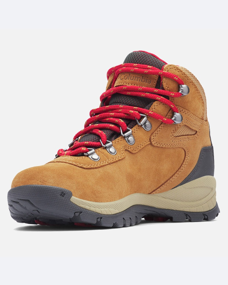 מגפי הטיולים ColumbiaIL Newton Ridge Plus Waterproof כוללים זמש חום בהיר, שרוכים אדומים, לולאות מתכת, קצה ועקב מחוזקים בצבע אפור, עיצוב אטום למים וסוליה מחוספסת ועמידה, המוצגים על רקע בהיר וחלק.