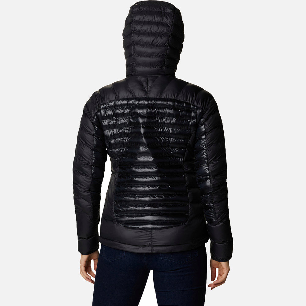 אדם הלובש את מעיל ה-Labyrinth Loop Hooded W השחור והמבריק מבית columbiaIL עומד עם גבו למצלמה על רקע לבן, ומדגיש בעדינות את הסגנון האלגנטי שלו.