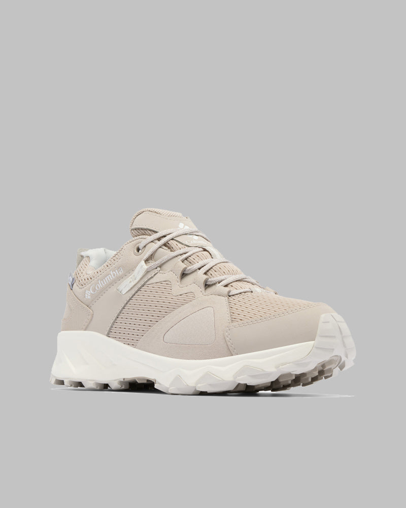 נעלי ספורט Peakfreak Hera Outdry של קולומביה ישראל בצבע בז', עם חלק עליון מרשת וחומר סינתטי, שרוכים לבנים וסוליה לבנה עבה על רקע אפור בהיר. נעל אידיאלית לפעילויות בחוץ ולהרפתקאות יומיומיות.