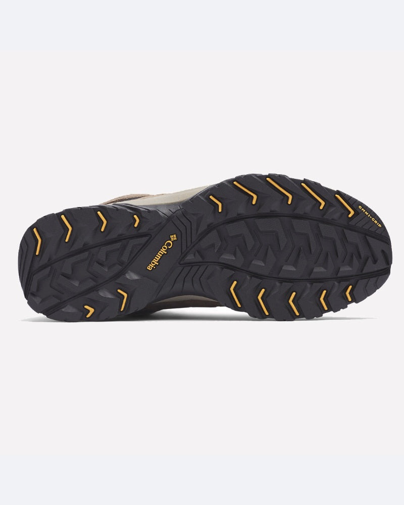 בתמונה נראית הסוליה של מגף הטיולים ColumbiaIL Crestwood Mid Waterproof, הכוללת סוליה חיצונית מגומי שחורה עם חריצים זוויתיים עמוקים ואלמנטים צהובים המעניקים אחיזה מעולה — אידיאלי לשימוש בשבילים.