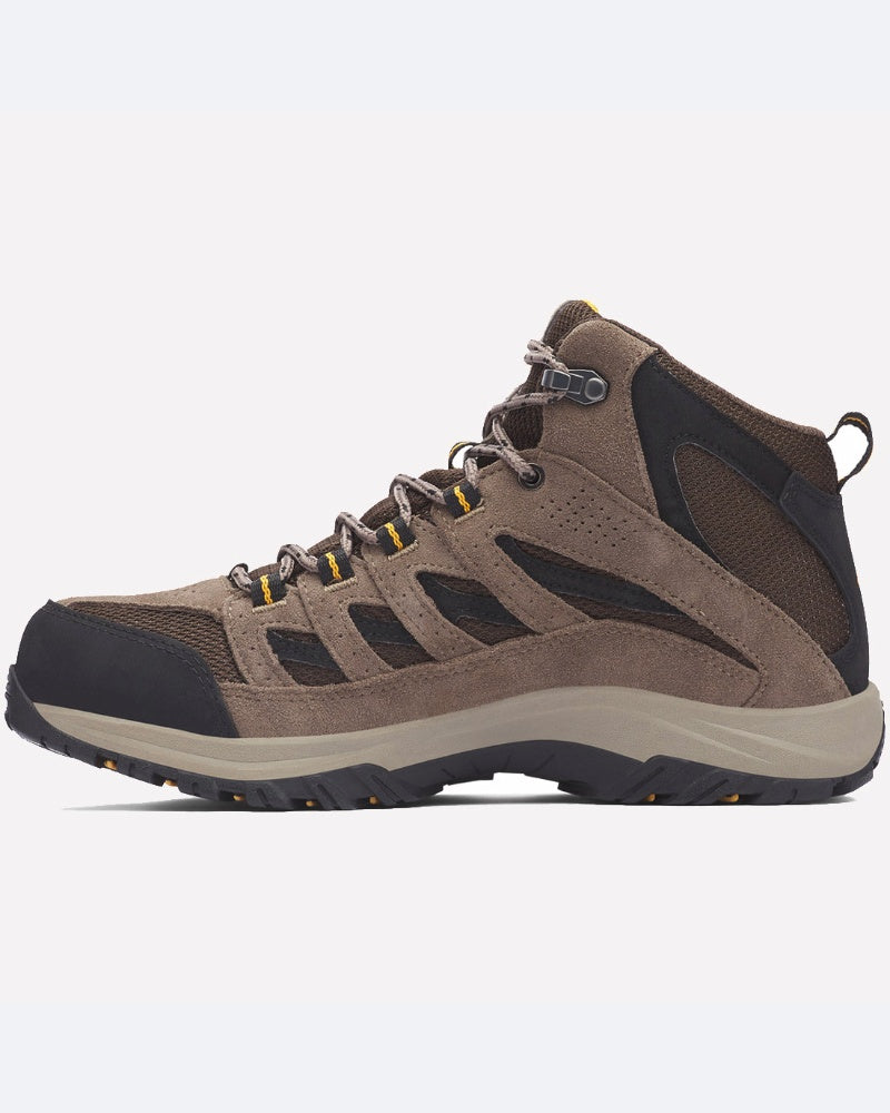 מגפי קולומביה IL Crestwood Mid Waterproof, המוצגים בפרופיל צדדי על רקע אחיד, מתאפיינים בעיצוב חום ושחור עם נגיעות צהובות, גובה עד אמצע הקרסול, לוחות רשת נושמים וסוליה גומי עמידה לאחיזה טובה.