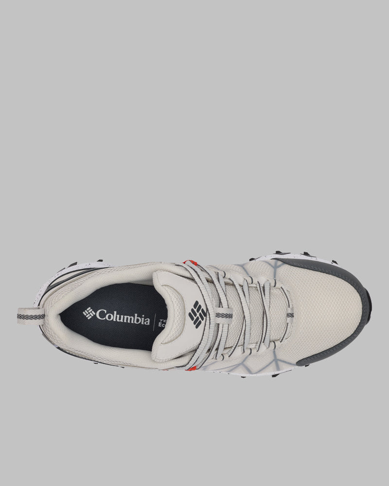 מבט מלמעלה על נעלי הספורט ColumbiaIL Peakfreak II Outdry עם גפה מרשת בצבע בז', נגיעות אפורות, שרוכים לבנים ורפידה שחורה עם לוגו ColumbiaIL, מצולמות על רקע אפור אחיד.