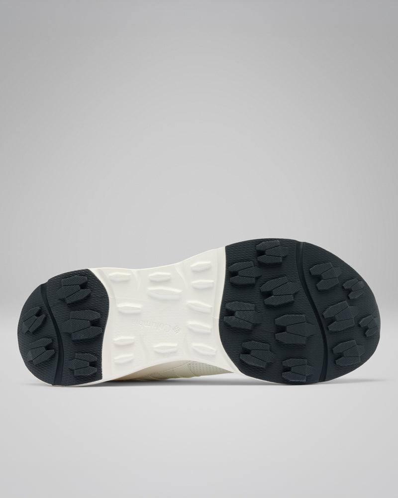 בתמונה נראית תמונת תחתית של סוליית ה-Terrastride Aro W של קולומביה ישראל, הכוללת דפוס צמיג עבה בשחור-לבן המעניק אחיזה ועמידות. רקע אפור אחיד מדגיש את העיצוב המחוספס של נעל הנשים הזו.