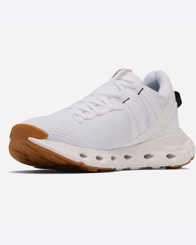 ה-Terrastride Aro של ColumbiaIL הוא נעל ספורט לבנה עם גפה מרשת, שרוכים לבנים, סוליה לבנה ועבה עם חיתוכים אליפטיים, וסוליה חיצונית מגומי חום. הנעל מוצגת כך שניתן לראות אותה הן מהצד והן מלפנים.