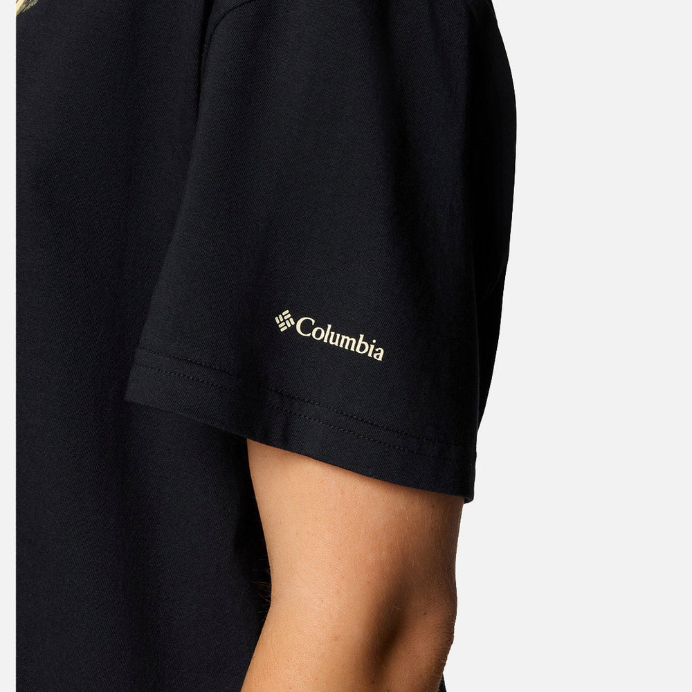 תקריב של זרועו העליונה של אדם הלובש את חולצת ה-Graphic Relaxed Crop Short Sleeve של קולומביהIL בצבע שחור, עם לוגו המותג בלבן על השרוול, על רקע לבן אחיד.