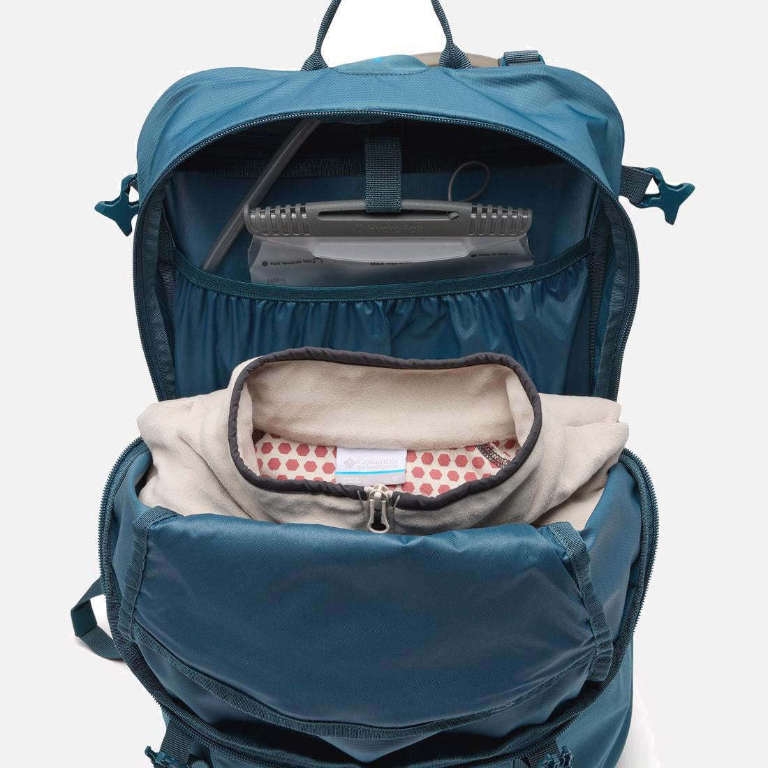 בתמונה נראית תיק הגב Blackcomb Ridge 30L של קולומביהIL פתוח, ובו ניתן לראות מחשב נייד בתוך הנרתיק המיועד לכך, נרתיק בצבע בז' עם בטנה מנוקדת, ותאי אחסון מסודרים בפנים.