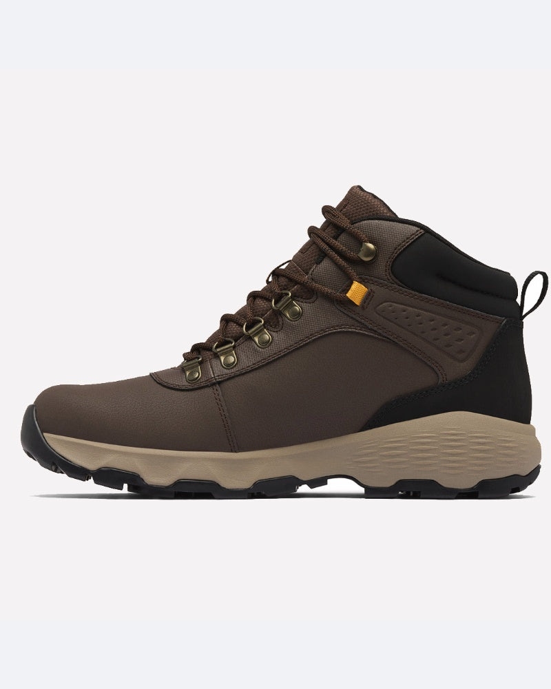 ה-Newton Wander Ltr של ColumbiaIL הוא מגף טיולים חום עם נגיעות שחורות, לולאות מתכת, שרוכים בצבע חום בהיר, סוליה מרקמת בצבע בז' ולשונית אחיזה בעקב — המוצג בתמונת פרופיל על רקע לבן — נעל הליכה גברית ועמידה.
