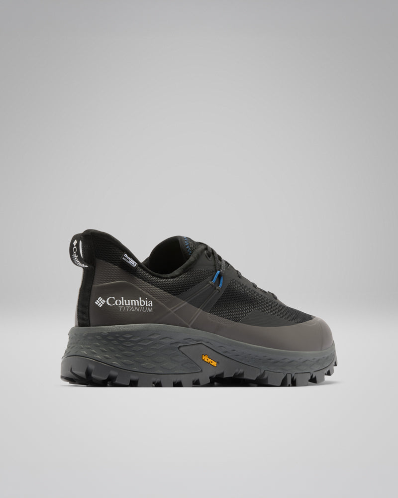 נעלי טיול מדגם Tellurix Titanium Outdry של קולומביה ישראל, בצבעים שחור ואפור, עם סוליה עמידה של Vibram, מוצגות במבט צדדי על רקע אפור בהיר אחיד — אידיאליות למי שמחפש נעלי שטח אמינות.